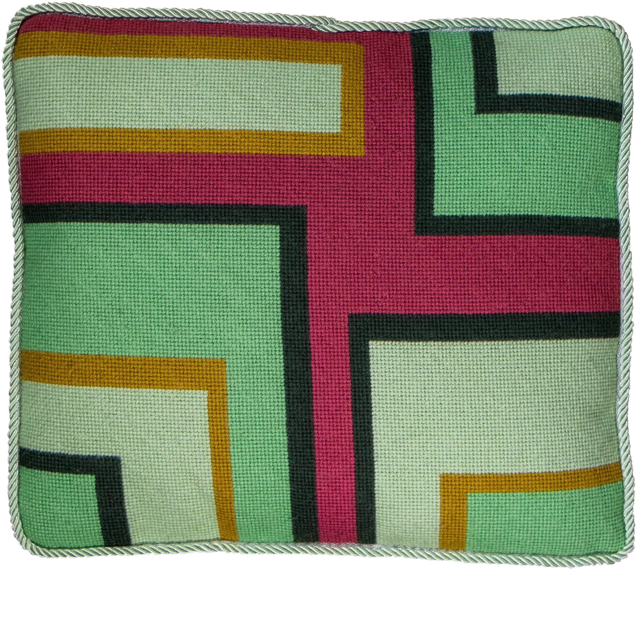A colorful geometric patterned needlepointed cushion on a blue couch. Designed and sold by Daisy’s Needlepoint Kits.